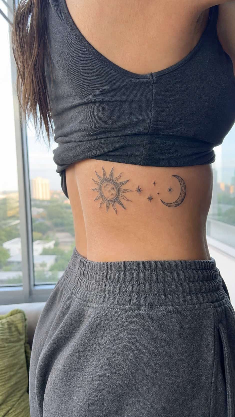 32 Stunning Rib Tattoos for Women 21 Healed sun and moon tattoo on a adult woman's side ribs, photographed in a natural casual close three-quarter view — study 2