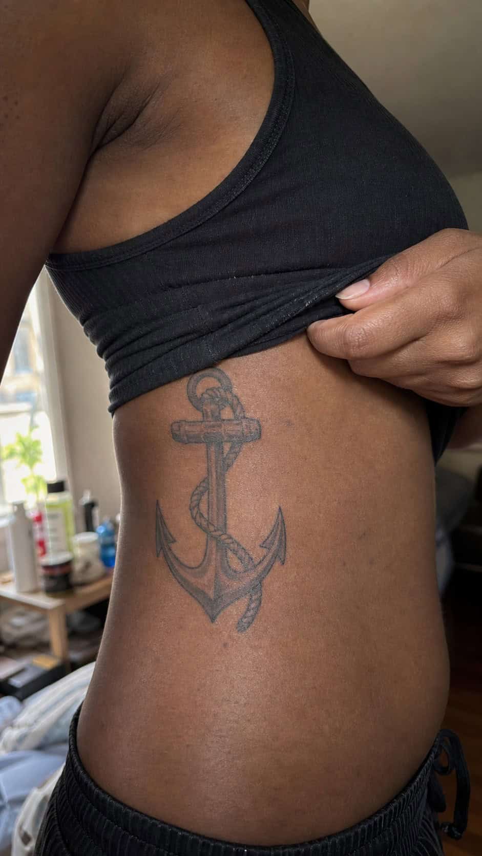 32 Stunning Rib Tattoos for Women 38 Healed anchor and rope tattoo on a adult woman's side ribs, photographed in a natural slightly elevated close view — study 2