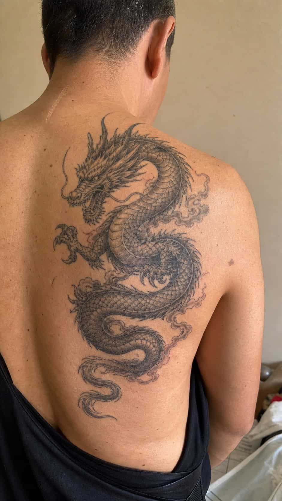 The Art of Ink: 23 Inspirational Back Tattoos for Men 2 Healed majestic dragon tattoo on a adult man's upper back, photographed in a natural straight-on close view, a touch off-center like a — study 1