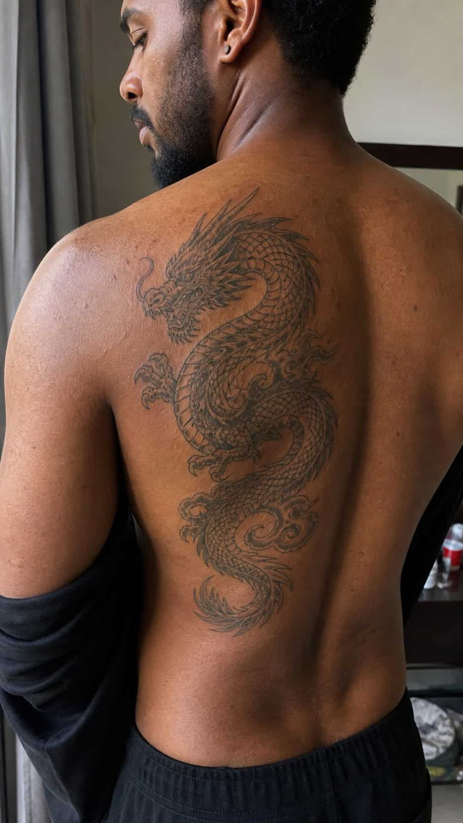 The Art of Ink: 23 Inspirational Back Tattoos for Men 3 Healed majestic dragon tattoo on a adult man's upper back, photographed in a natural gentle side angle that clearly shows how the ink — study 2