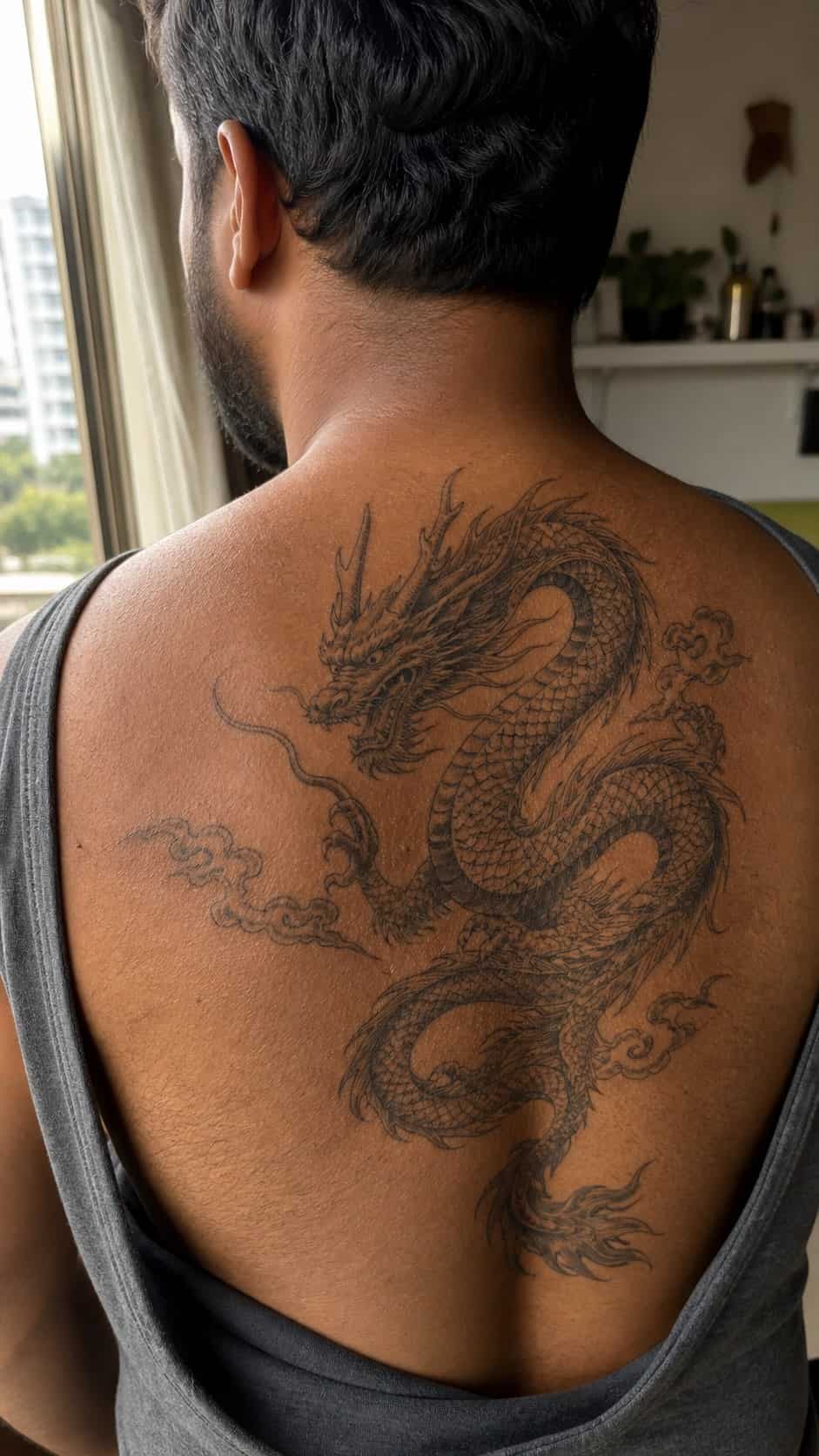 The Art of Ink: 23 Inspirational Back Tattoos for Men 4 Healed majestic dragon tattoo on a adult man's upper back, photographed in a natural slightly elevated close view — study 3