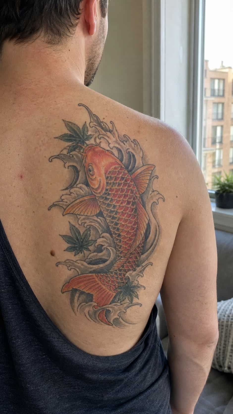 The Art of Ink: 23 Inspirational Back Tattoos for Men 11 Healed japanese koi fish tattoo on a adult man's upper back, photographed in a natural straight-on close view, a touch off-center like — study 2