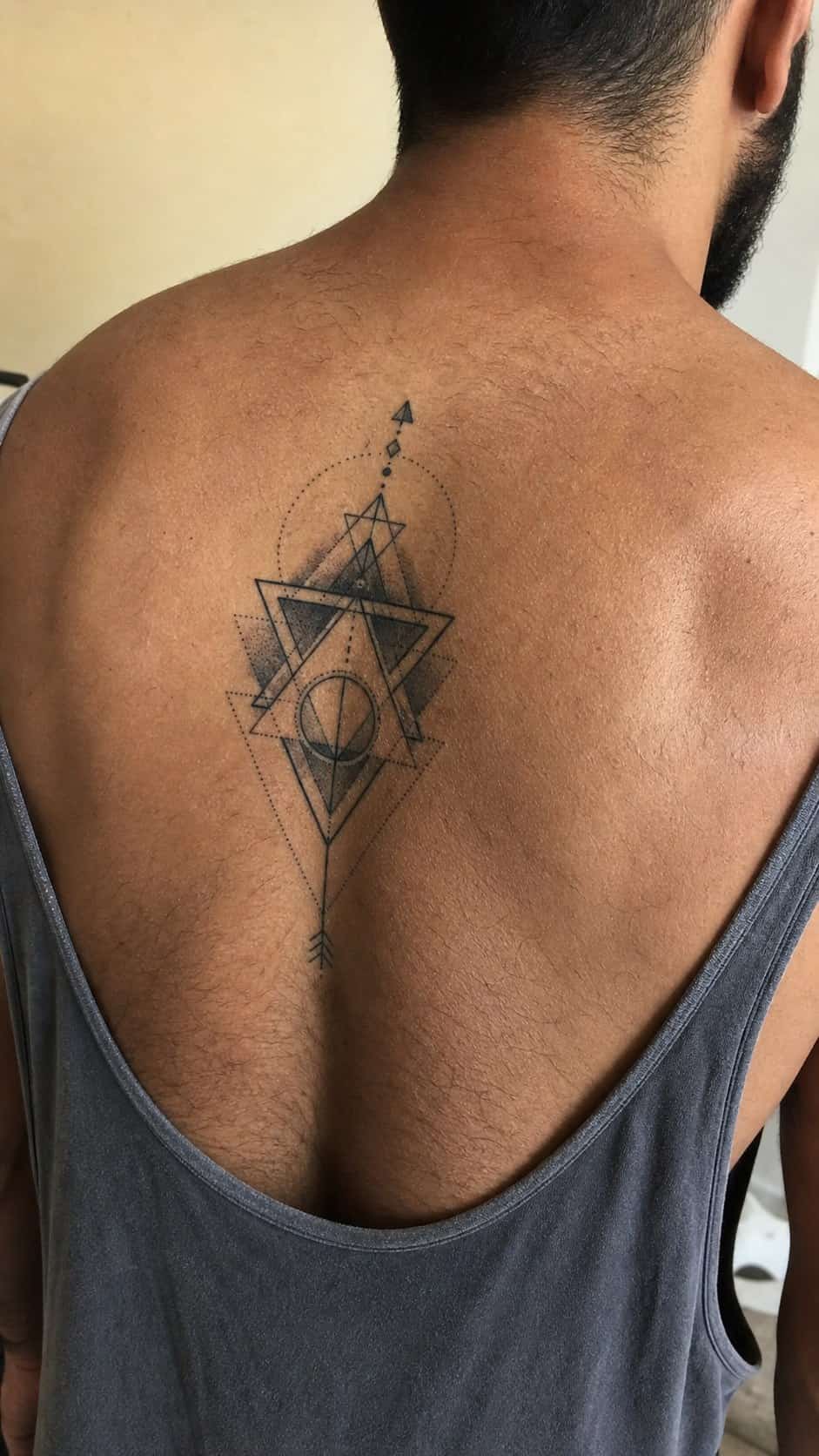 The Art of Ink: 23 Inspirational Back Tattoos for Men 13 Healed geometric patterns tattoo on a adult man's upper back, photographed in a natural straight-on close view, a touch off-center — study 2