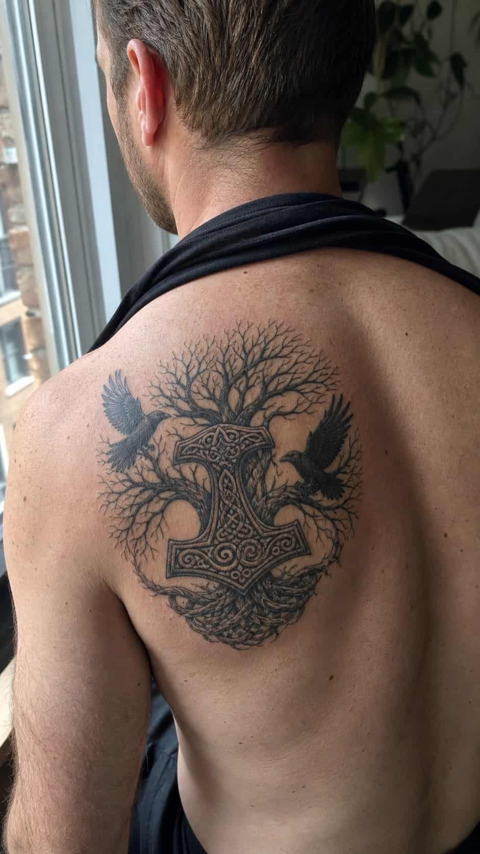 The Art of Ink: 23 Inspirational Back Tattoos for Men 17 Healed norse mythology tattoo on a adult man's upper back, photographed in a natural relaxed documentary crop — study 2