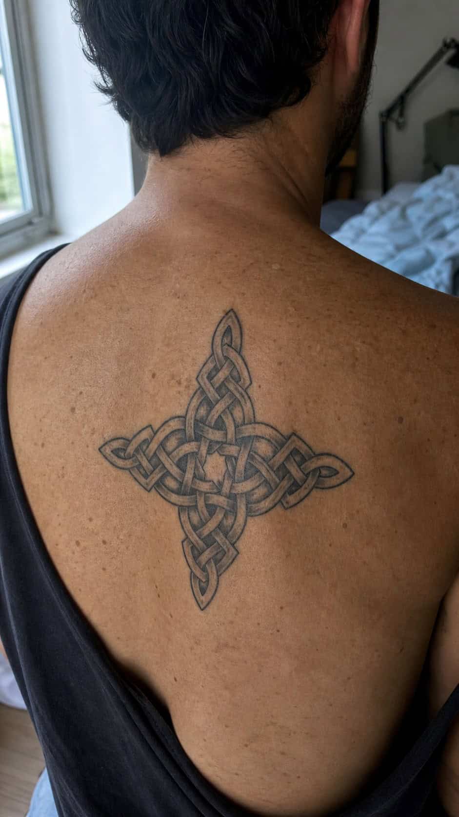 The Art of Ink: 23 Inspirational Back Tattoos for Men 18 Healed celtic knotwork tattoo on a adult man's upper back, photographed in a natural straight-on close view, a touch off-center like a — study 1