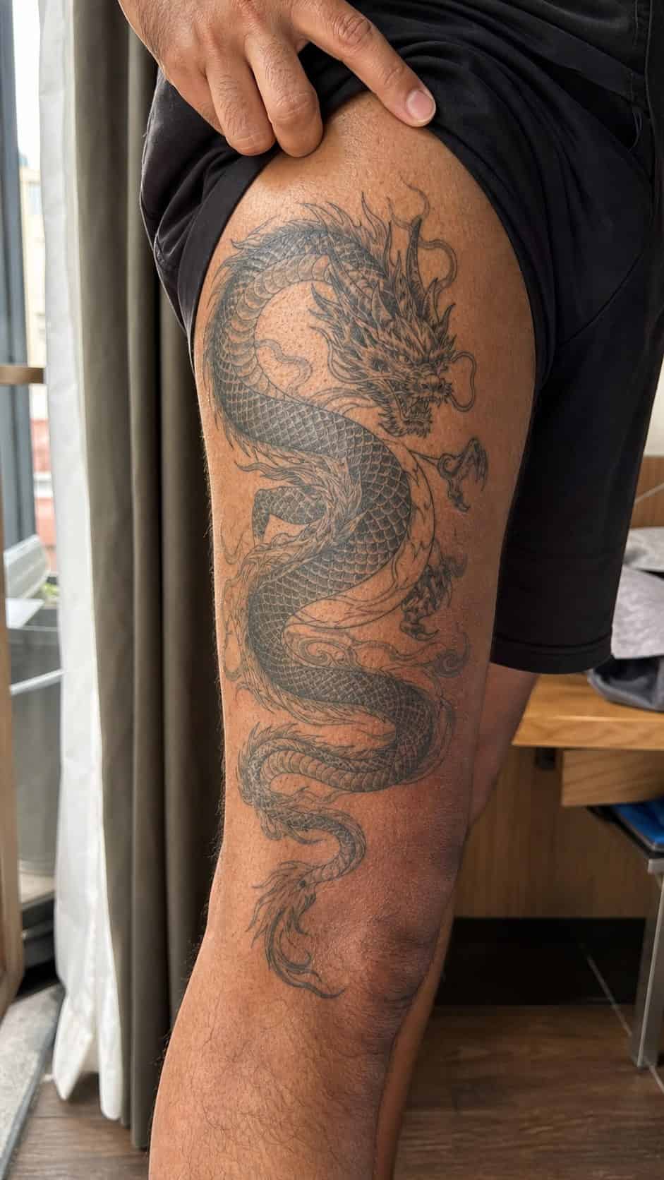 Feeling Bold? Try These 25 Killer Thigh Tattoo Ideas for Men 21 Healed detailed dragon coiling tattoo on a adult man's outer thigh, photographed in a natural gentle side angle that clearly shows how — study 1