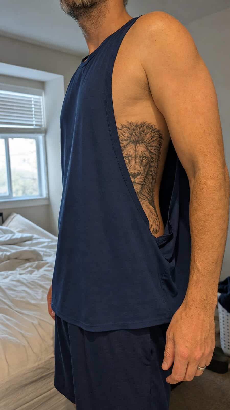Healed fierce lion tattoo on a adult man's side ribs, photographed in a natural straight-on close view, a touch off-center like a — study 2