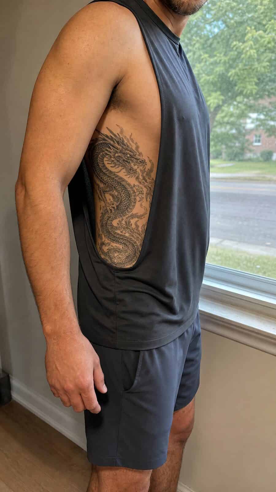 Healed dragon’s fury tattoo on a adult man's side ribs, photographed in a natural straight-on close view, a touch off-center like a — study 2