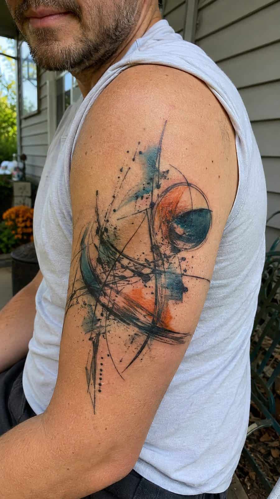 48 Tattoo Ideas for Men Worth Considering for Your Next Ink 30 Healed abstract expressions tattoo on a adult man's outer upper arm, photographed in a natural waist-height candid close-up — study 1
