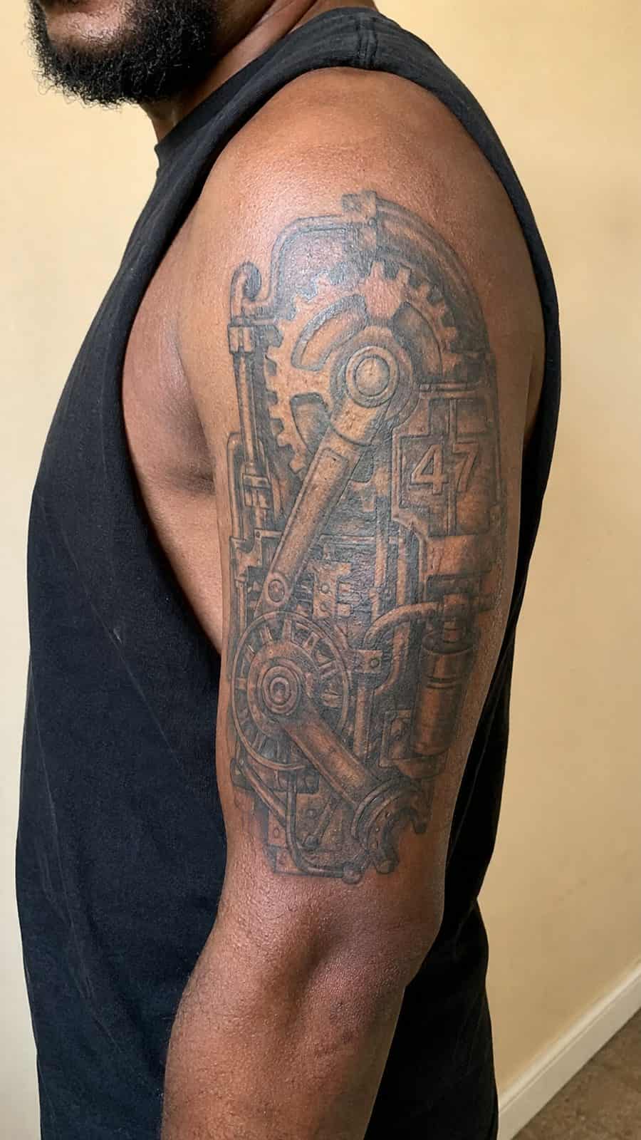 48 Tattoo Ideas for Men Worth Considering for Your Next Ink 32 Healed industrial grit tattoo on a adult man's outer upper arm, photographed in a natural slightly elevated close view — study 1