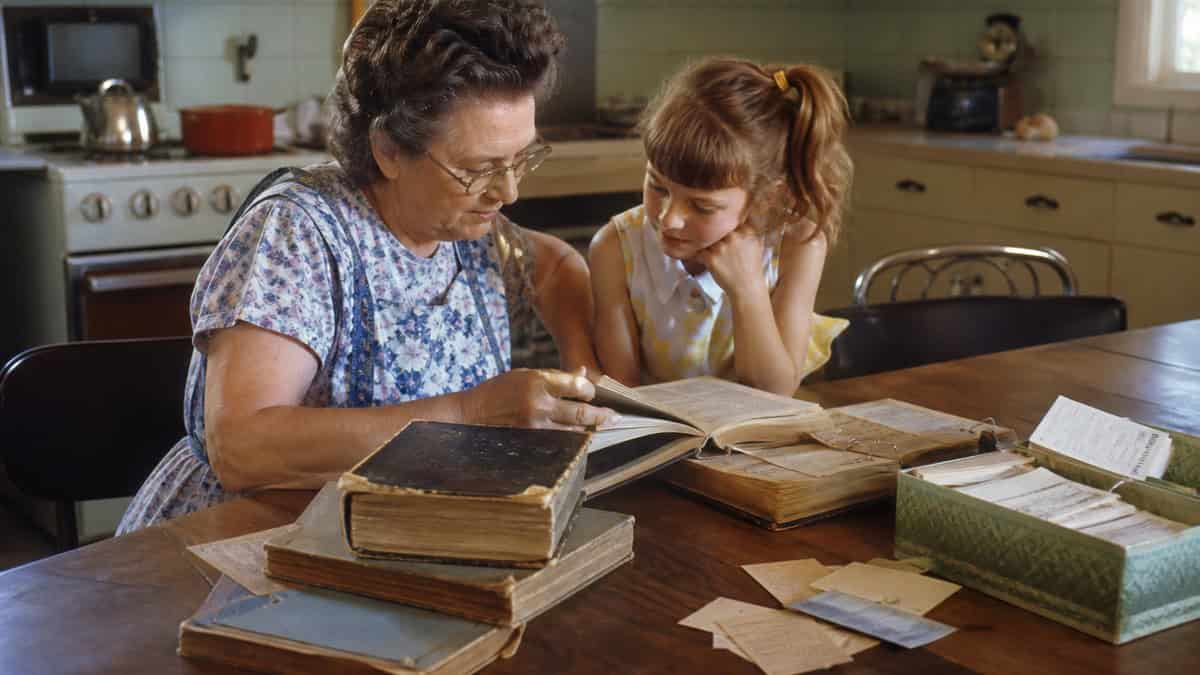 26 Things Grandma Never Threw Away (That Are Worth a Fortune Now) 13 Grandmother sharing worn vintage cookbooks with a child in the early 1960s