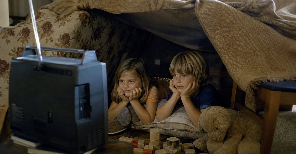 Children watching cartoons from a blanket fort in the 1970s