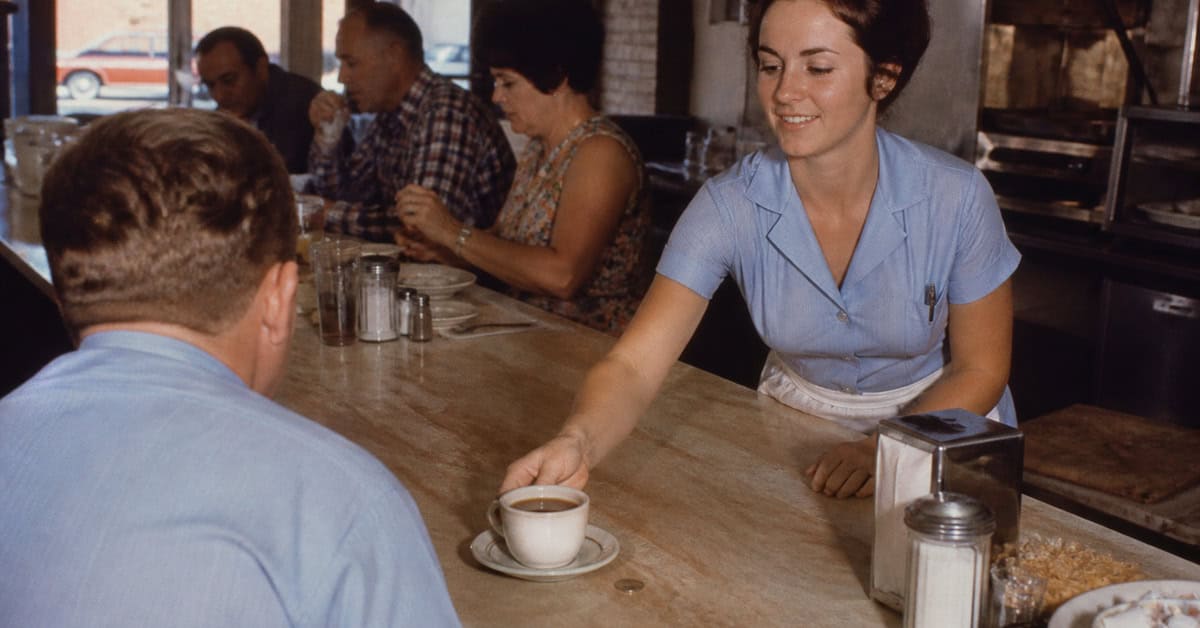 Cup of diner coffee beside a quarter in 1970