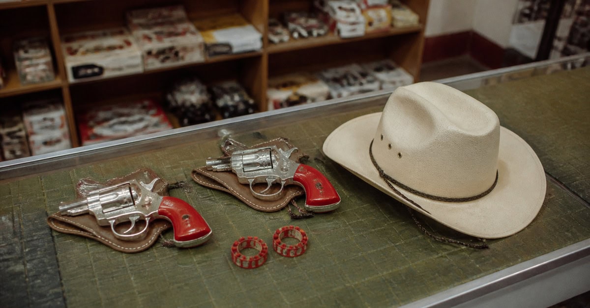 What You Could Actually Buy for Under a Dollar at the Toy Store 16 Toy cowboy cap pistols and holsters on a 1960s toy-store counter