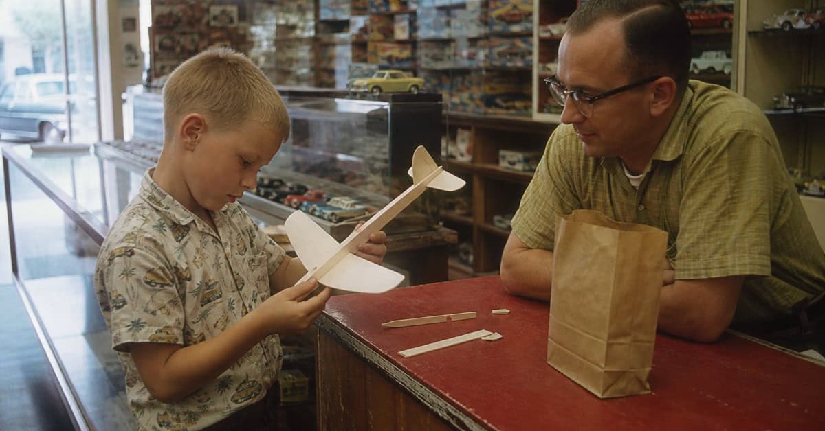 What You Could Actually Buy for Under a Dollar at the Toy Store 3 Child assembling a balsa wood glider at a 1960s toy-store counter