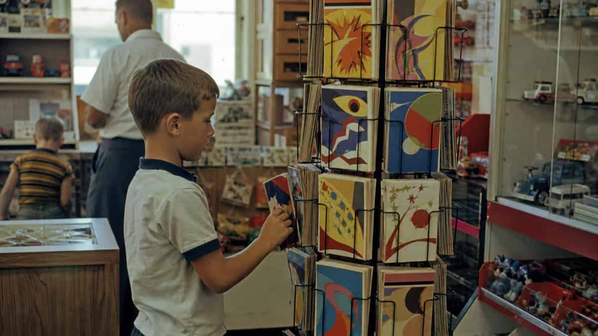 What You Could Actually Buy for Under a Dollar at the Toy Store 5 Child browsing a comic-book rack at a 1960s toy store