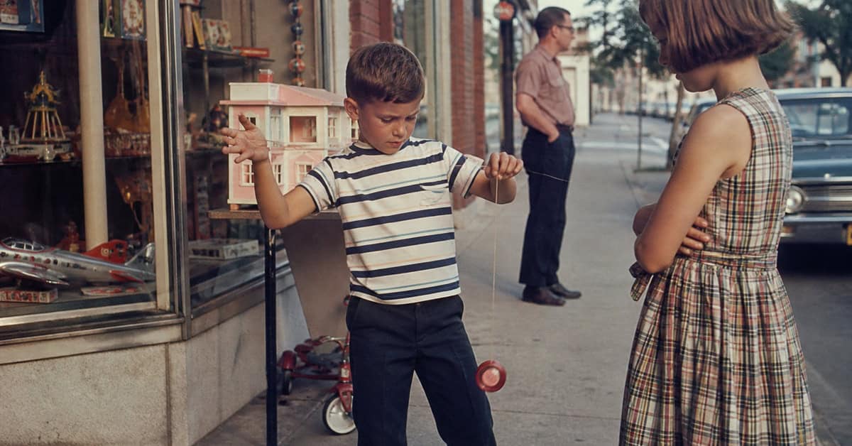 What You Could Actually Buy for Under a Dollar at the Toy Store 8 Child practicing with a yo-yo outside a 1960s toy store