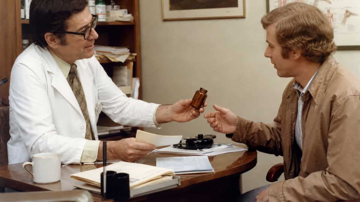 What 1970s Doctors Did That Would Lead to Lawsuits Today 7 Doctor handing a patient an antibiotic bottle in a 1970s medical office