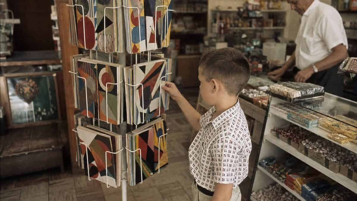14 Things You Could Buy for a Nickel in 1960 (That Cost $20+ Now) 11 Child choosing a comic book from a spinner rack in 1960