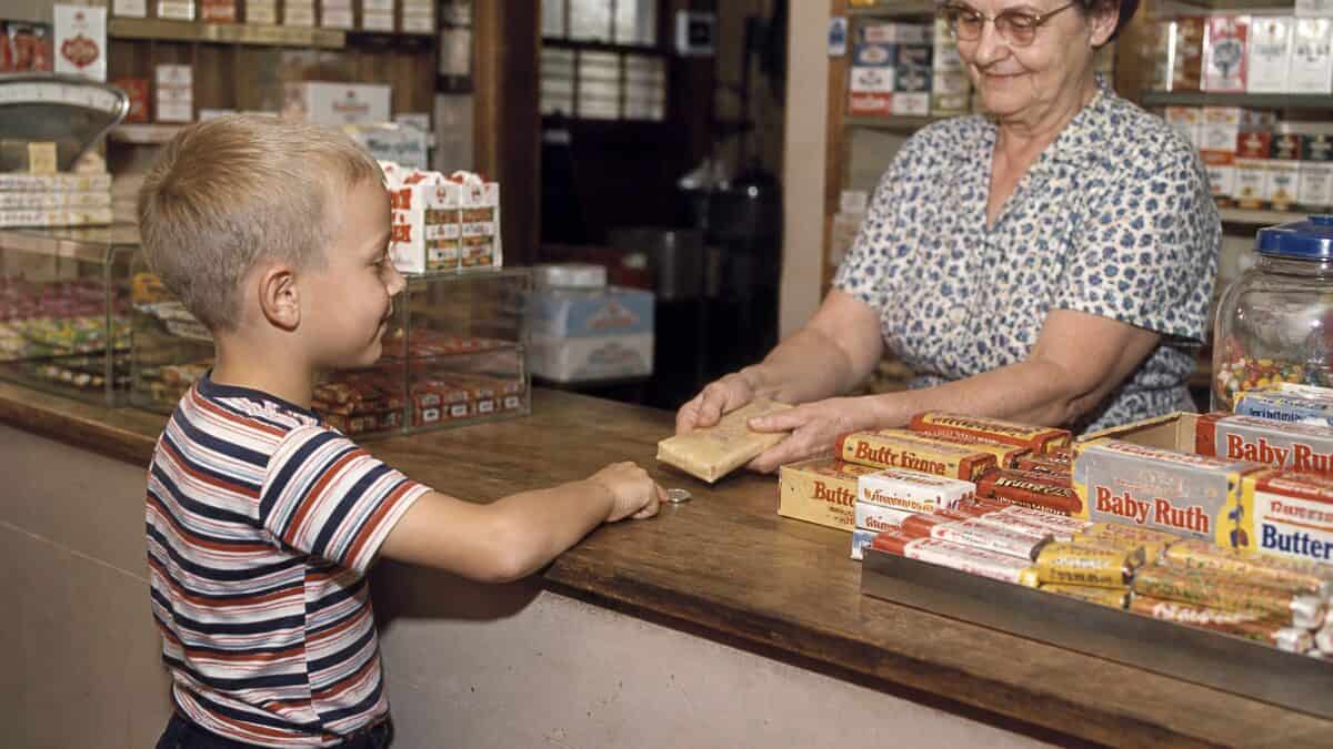 14 Things You Could Buy for a Nickel in 1960 (That Cost $20+ Now) 3 Child buying a full-size candy bar with a nickel in 1960