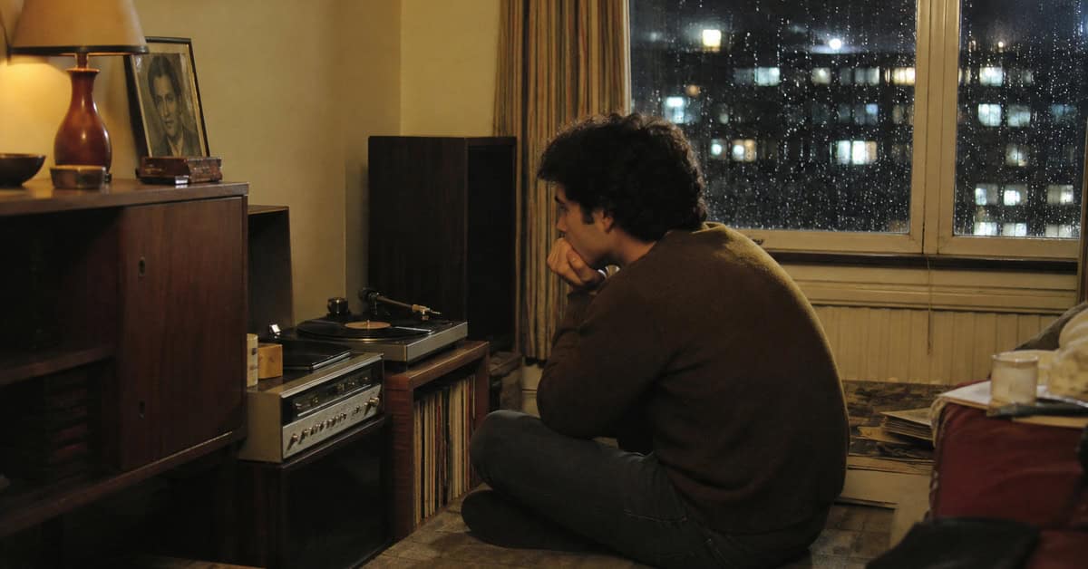 13 Classic Rock Ballads That Instantly Take You Back 9 Young adult listening quietly to a record on a rainy night in the 1960s