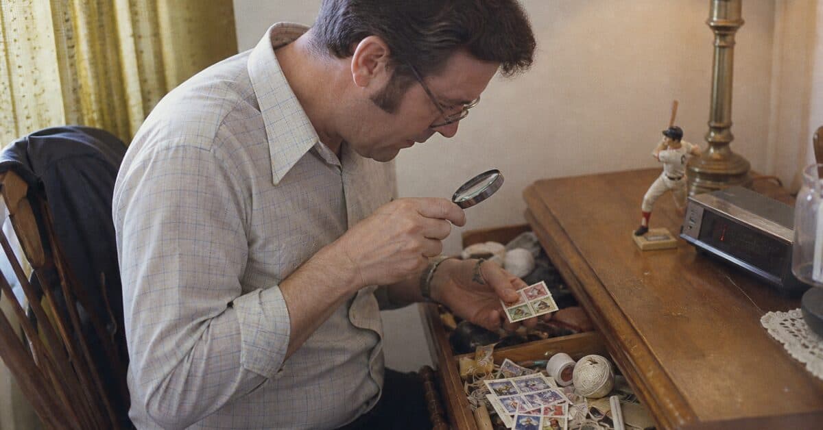 15 Items in Your Junk Drawer That Could Be Worth Real Money 14 Collector inspecting vintage postage stamps from a junk drawer