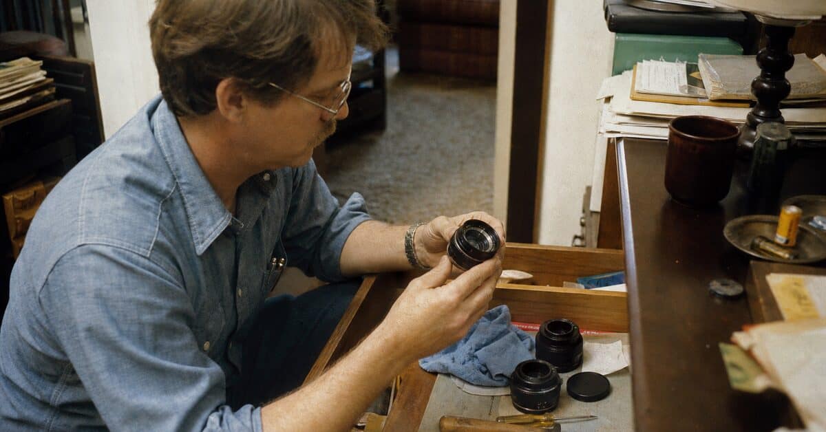 15 Items in Your Junk Drawer That Could Be Worth Real Money 6 Adult examining vintage camera lenses found in a junk drawer