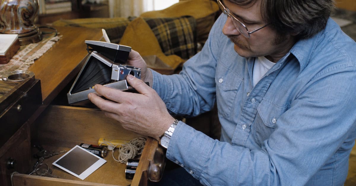 15 Items in Your Junk Drawer That Could Be Worth Real Money 7 Adult finding a vintage instant camera in a household junk drawer