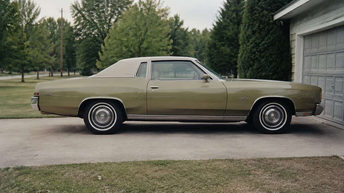 1970s family car parked beside a suburban garage