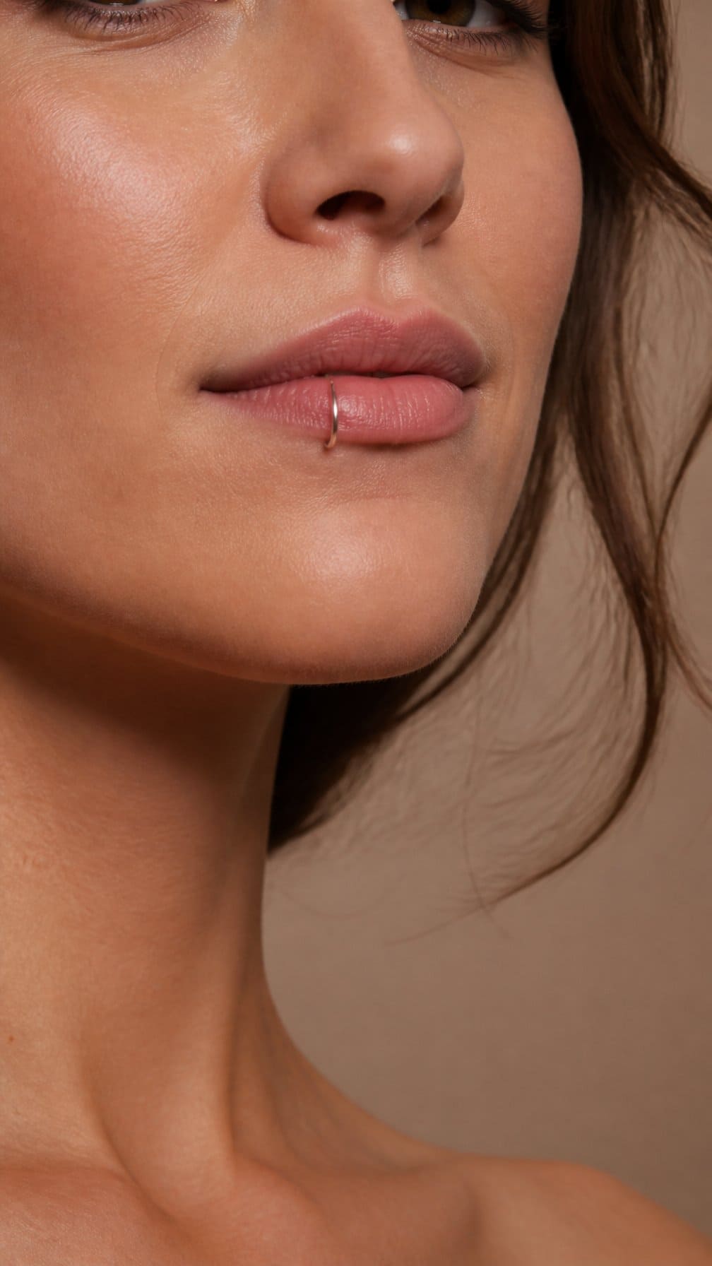 Close-up of a person wearing a thin seamless ring in their lower lip.