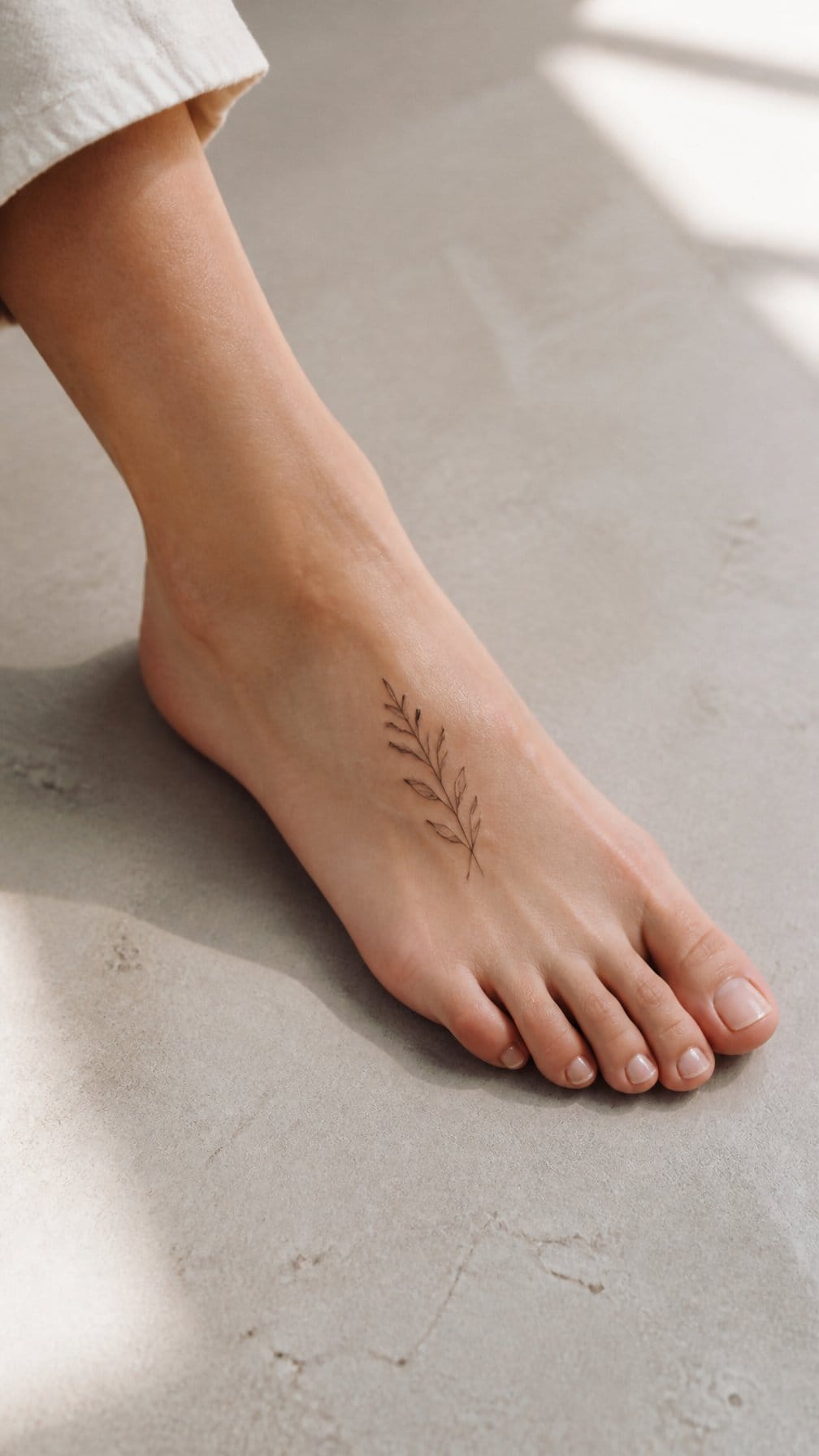 A foot with a small delicate tattoo on the top of the instep.