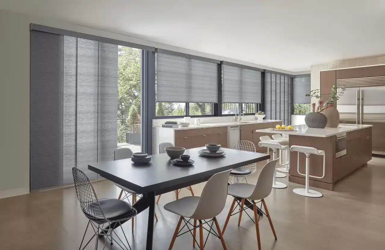Bright, airy kitchen featuring gray roller shades, minimalist design, and contemporary furniture with a spacious dining area.
