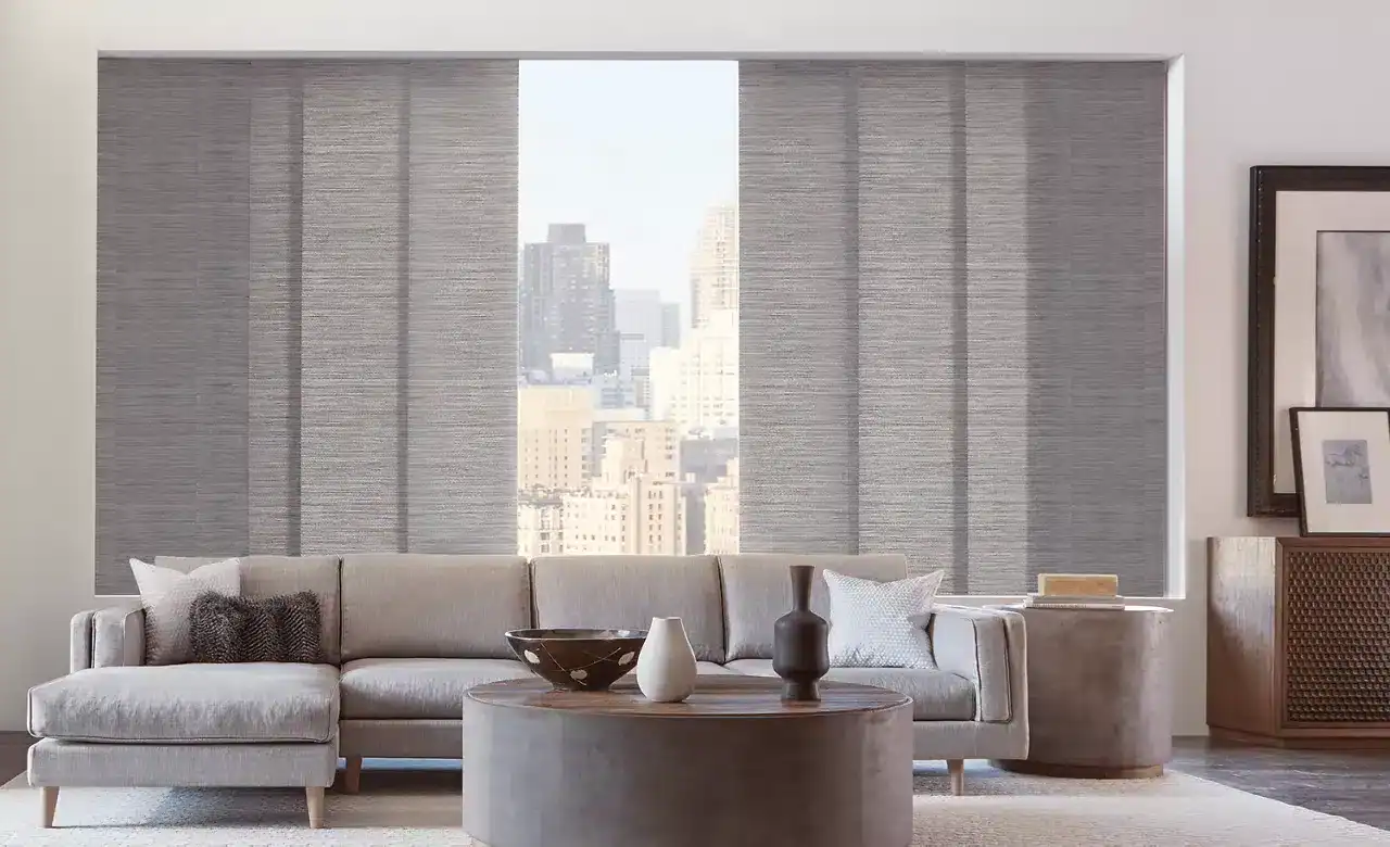 Bright living room with large cityscape window, neutral-toned sofa, contemporary decor, and stylish accessories for urban home design.