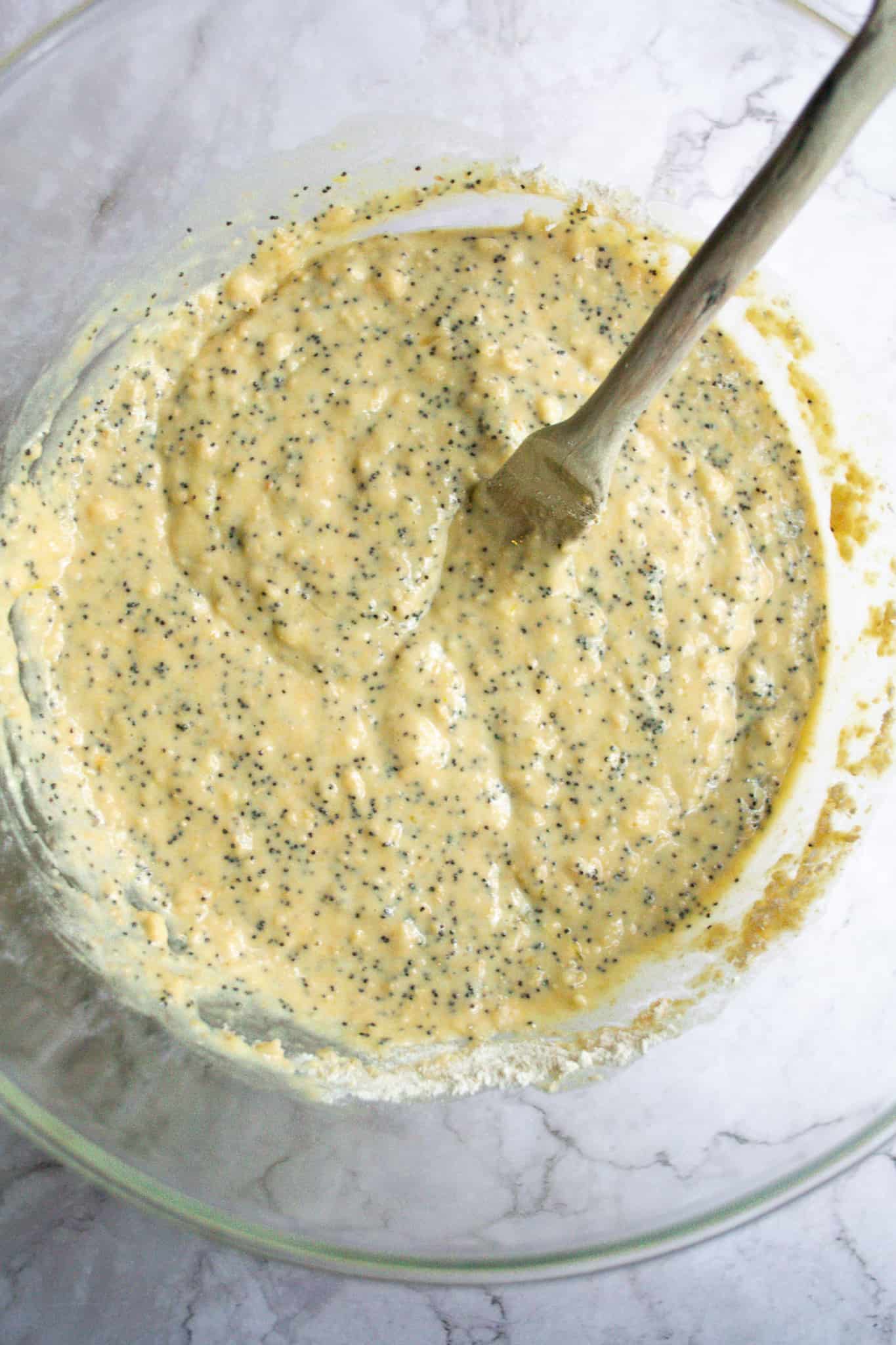 Batter in a bowl with poppyseeds mixed in.