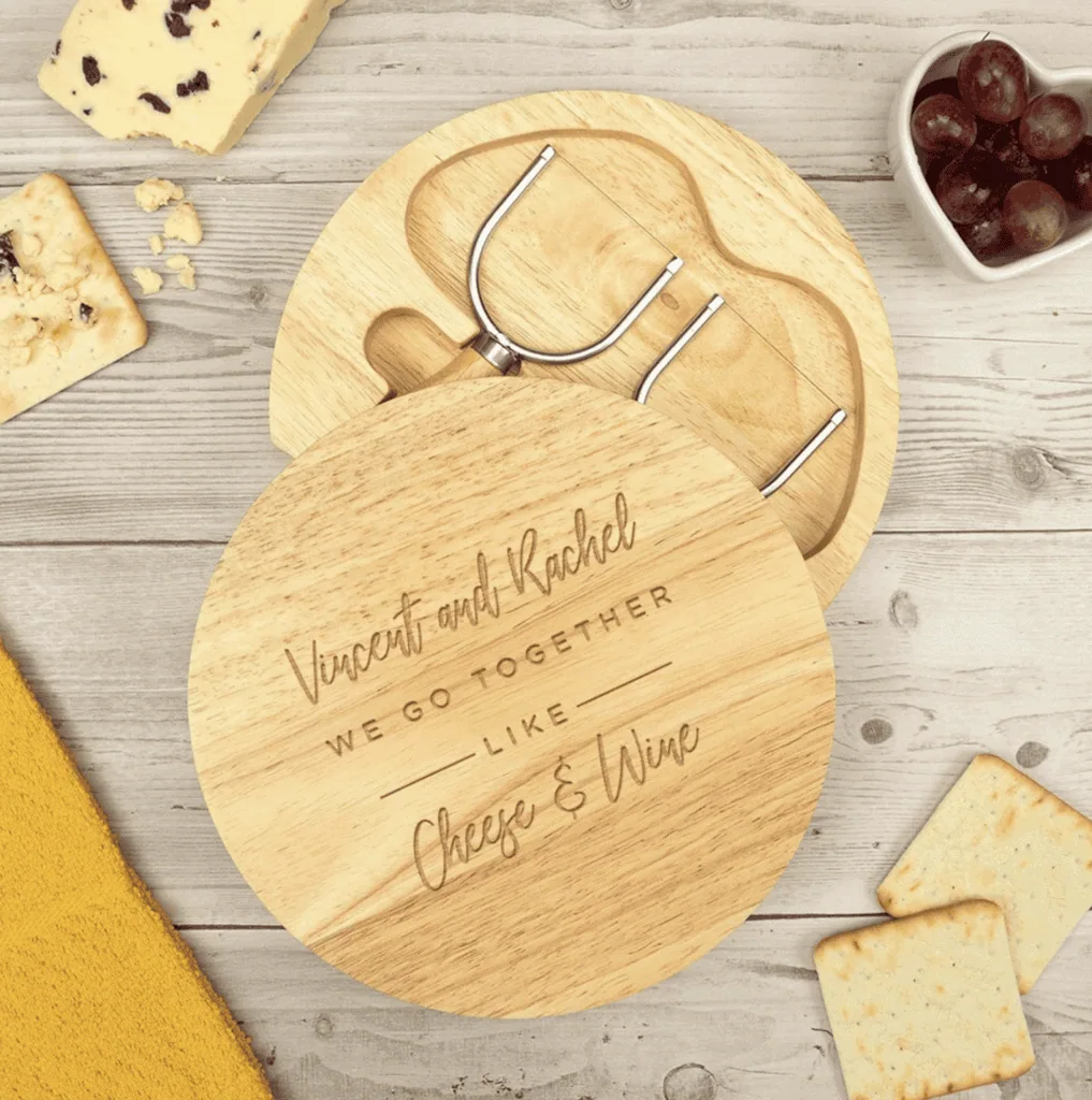 Overhead view of a custom charcuterie board with the quote 'Vincent and Rachel, we go together like cheese & wine'.