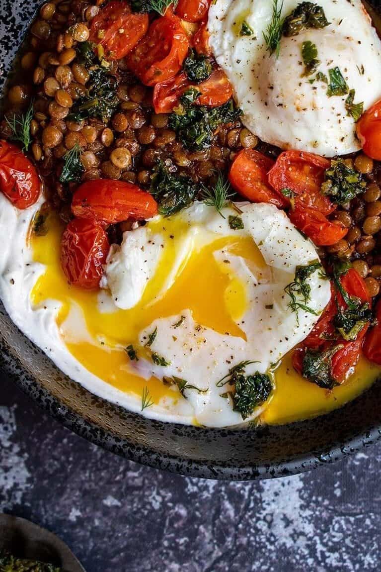 Overhead shot of braised lentils with poached egg from Cherry on My Sundae with lentils, tomatoes, parsley, and egg.
