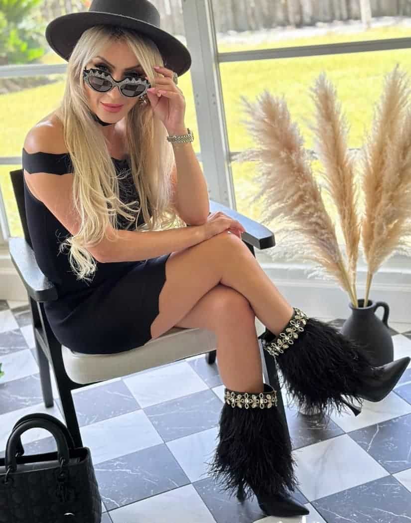 girl sitting by window with sunglasses wearing The Foxy Black Leather Stiletto Boot with Premium Feathers