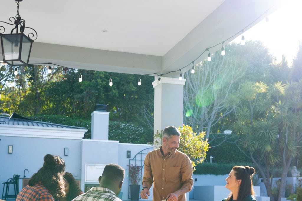 Friends visiting under a backyard patio cover