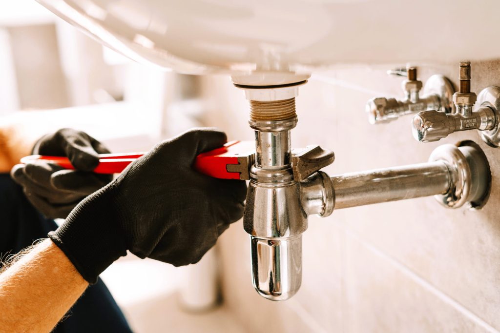 plumber using a wrench repairing a sink