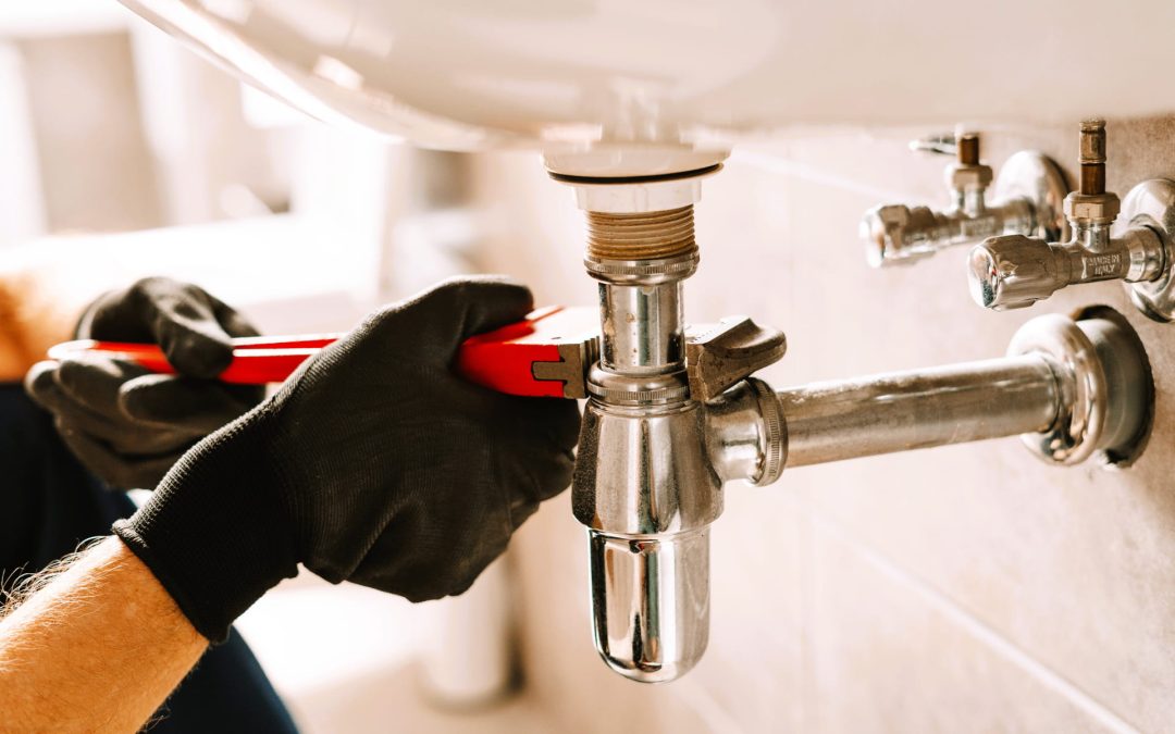 plumber using a wrench repairing a sink