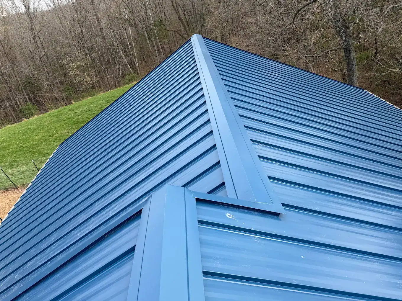 Metal roofing with blue panels on a residential building.