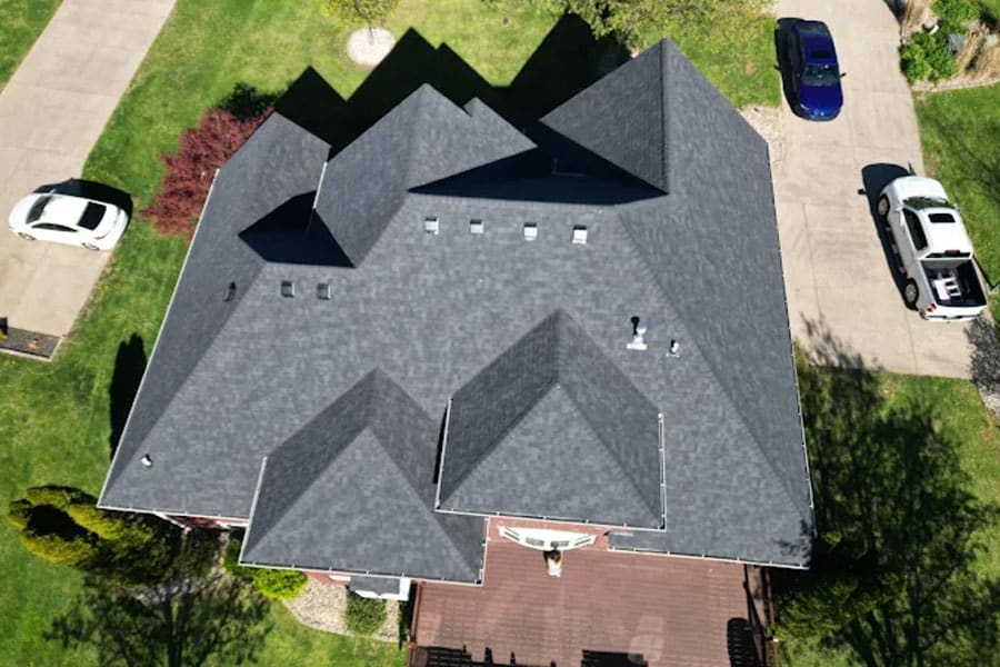 Expert roofing installation on a large residential home with durable shingles.