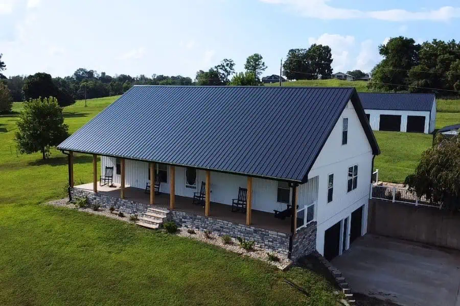 Beautiful white house with durable metal roofing and spacious porch.