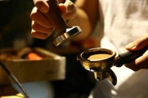 someone using an espresso tamper
