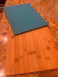 a plastic and wood cutting board next to one another