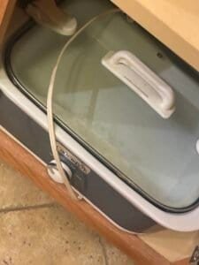 slow cooker in a cabinet for storage