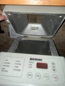 a bread machine open on counter in kitchen