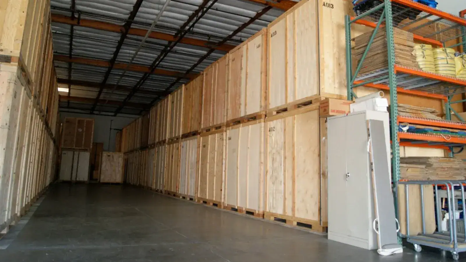 Storage facility interior with stacked wooden crates and shelving, illustrating options for moving and storage solutions.