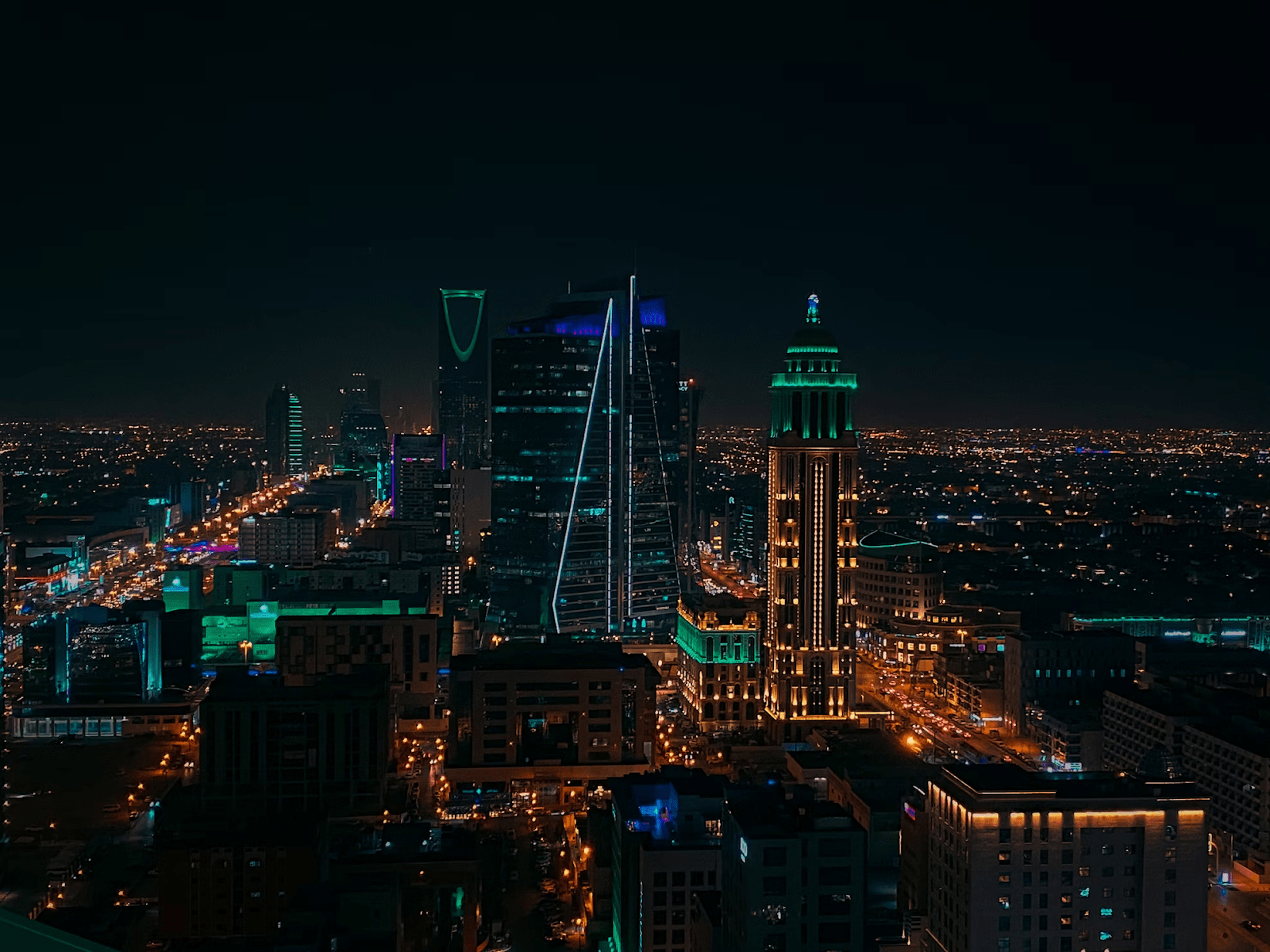 Skyscrapers alongside other real estate projects illuminated at night in Riyadh, Saudi Arabia - (Credits Unsplash)