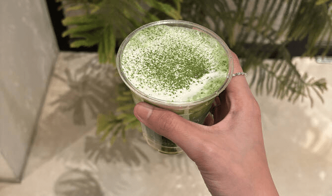 A person holding a cup of matcha in a cafe in Saudi Arabia - (Credits Arab News)